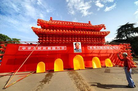 A citizen takes photos in front of a model of Tian'anmen in Changsha, capital of central China's Hunan Province, Sept. 22, 2009. Parks and other scenic sites of the city are decorated to celebrate the 60th anniversary of the founding of the People's Republic of China which falls on Oct. 1.(Xinhua/Long Hongtao) 