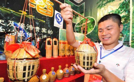 An exihibitor introduces sticky rice wine at the China Wine & Liquor Expo in Zunyi city of southwest China&apos;s Guizhou Province, Sept. 22, 2009. Nearly 4,000 wine producers and dealers participated in the expo that opened on Tuesday.(Xinhua/Yang Ying) 