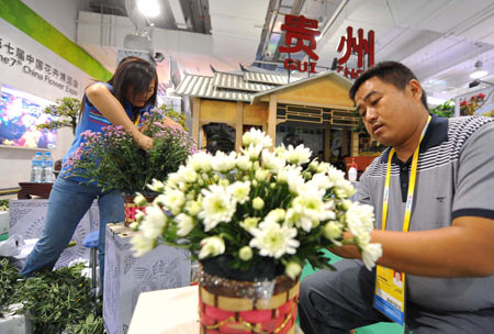 Staffs of Guizhou booth arrange flowers for the Seventh China Flowers Expo in Beijing, China, Sept. 23, 2009. Over 1,300 companies will participate in the Seventh China Flowers Expo that opens on Sept. 26. (Xinhua/Luo Xiaoguang) 