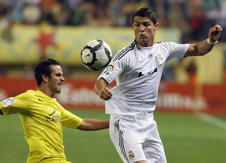 Real Madrid's Cristiano Ronaldo (R) controls the ball past Villarreal's Angel Lopez during their Spanish first division soccer match at the Madrigal Stadium in Villarreal September 23, 2009.