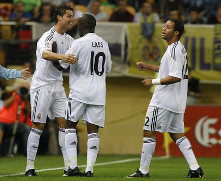 Real Madrid's Cristiano Ronaldo (L) celebrates a goal against Villarreal with team mates Lassana Diarra (C) and Marcelo during their Spanish first division soccer match at the Madrigal Stadium in Villarreal September 23, 2009.