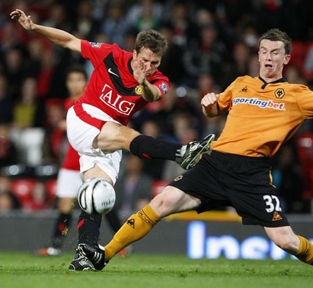 Manchester United's Michael Owen (L) is challenged by Wolverhampton Wanderers' Kevin Foley during their English League Cup soccer match at Old Trafford in Manchester, northern England, September 23, 2009.