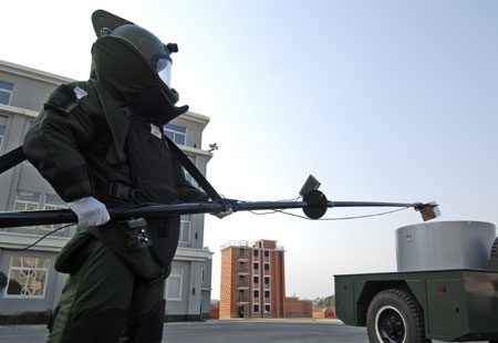 A policeman clears an 'explosive' with a mechanical arm during an anti-explosive drill in Dandong city of northeast China