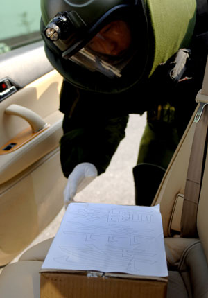 A policeman checks an 'explosive' during an anti-explosive drill in Dandong city of northeast China