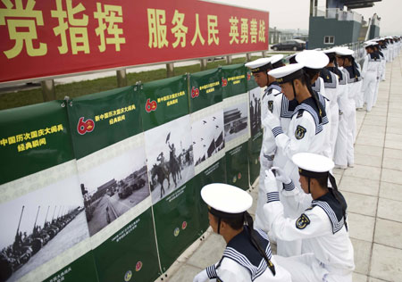 Soldiers watch photos at the Parade Photo Exhibition in Beijing, China, Sept. 24, 2009. A photo exhibition recording previous parades after the founding of the People's Republic of China in 1949 was held at Parade Village where all the soldiers who will join the parade on Oct.1 take part in practices. (Xinhua/Liu Jie) 