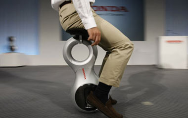 A Honda Motor Co employee demonstrates the company's prototype of new personal mobility device 'U3-X' during its unveiling at the company headquarters in Tokyo Sept. 24, 2009. The U3-X, equipped with the world's first omni-directional driving system, makes it possible to adjust speed and move, turn and stop an all directions when rider leans the upper body to shift body weight, Honda said.[