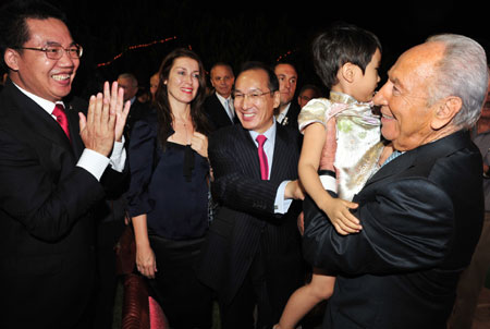 Israeli President Shimon Peres (1st R) and Chinese Ambassador to Israel Zhao Jun (C) attend a reception held by the Chinese Embassy to mark the 60th anniversary of the founding of the People's Republic of China, in Tel Aviv, Israel, Sept. 24, 2009. (Xinhua)