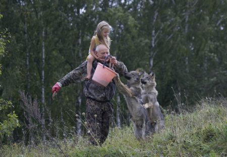 A man and his daughter play with tame wolves in the village of Nadbiarezha, some 250 km (156 miles) northwest of Minsk, September 23, 2009.