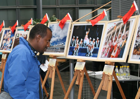 A visitor has a look at a photo displayed in an exhibition to mark the 60th anniversary of founding of the People's Republic of China in Haaga-Helia University of Applied Sciences, Helsinki, capital of Finland, Sept. 25, 2009. (Xinhua/Zhao Changchun)
