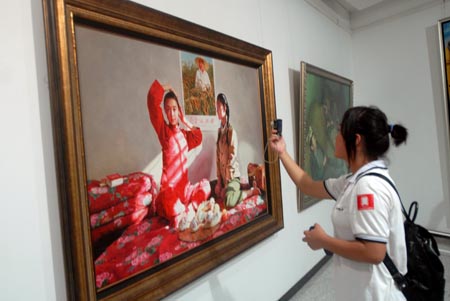 A girl visitor takes pictures of an oil painting at China's 11th National Oil Painting Works Exhibition in Wuhan, central China's Hubei province, Sept. 26, 2009. The exhibition opens on Saturday to the public free of charge until early November this year. (Xinhua)