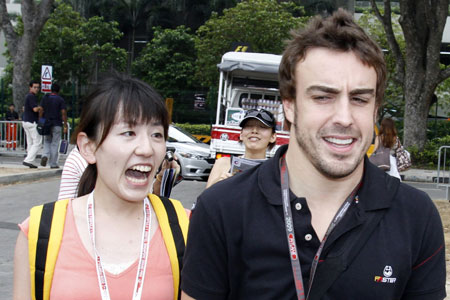 A fan screams with excitement after Renault Formula One driver Fernando Alonso of Spain signed autographs for her as he arrives at the pits before the start of the first practice session of the Singapore F1 Grand Prix at the Marina Bay street circuit September 25, 2009.