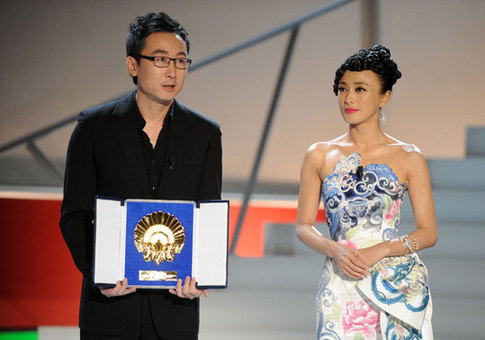 'City of Life and Death' director Lu Chuan (left), accompanied by cast member Qin Lan, accepts the Golden Shell award at the San Sebastian Film Festival in San Sebastian, Spain on September 26, 2009.