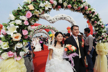 A groom walks with his bride during a mass wedding in Qingdao, east China
