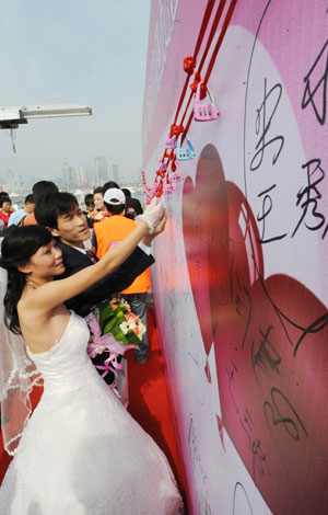 A couple hangs a "heart lock" during a mass wedding in Qingdao, east China