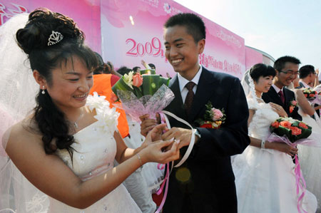 A couple exchanges the rings during a mass wedding in Qingdao, east China