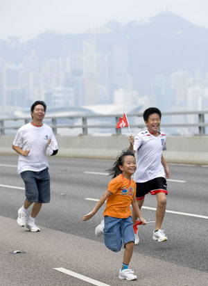 Local residents walk on the eastern corridor of Hong Kong, south China, on Sept. 27, 2009. More than 13,000 people took part in the charity walk activity held here on Sunday to celebrate the 60th anniversary of the founding of the People's Republic of China. (Xinhua/Lui Siu Wai) 