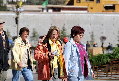 Foreign tourists walk in the street in Lhasa, capital of southwest China's Tibet Autonomous Region, on Sept. 27, 2009. There are no restrictions on foreigners' travel to Tibet during the National Day holiday season, according to an official with the Tibet Autonomous Regional Tourism Administration.