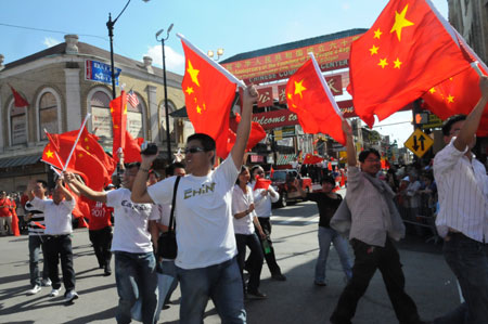 People hold national flags of the People's Republic of China during a parade in Chinatown of Chicago, the United States, on Sept. 27, 2009. The parade was held here on Sunday to celebrate the upcoming 60th anniversary of the founding of the People's Republic of China. (Xinhua/Hu Guangyao)