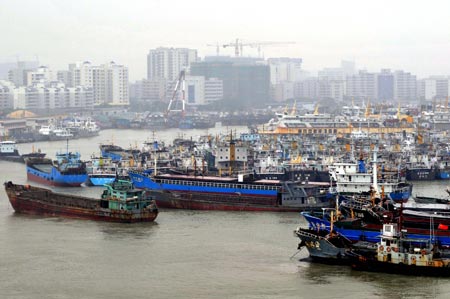 Ships anchor at a harbor in Haikou, south China's Hainan Province, on Sept. 28, 2009. As tropical storm Kestana approaches, local maritime affairs departments on Monday ordered vessels to return to harbor and suspended part of shipping services across the Qiongzhou Strait, which connects the Hainan Island to the mainland. [Guo Cheng/Xinhua]