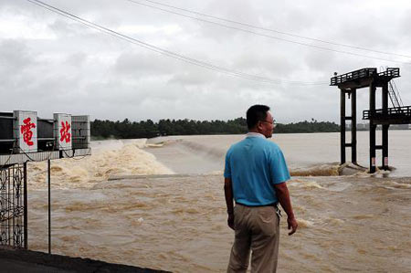 A man watches the flood brought by the typhoon Kestana at Jiaji Hydropower Station, in Qionghai, south China's Hainan Province, Sept. 29, 2009. The typhoon Kestana has affected Qionghai City with continuous gale and forced the Jiaji Hydropower Station to stop work. [Xinhua]