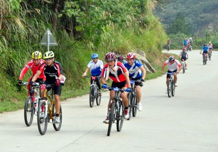 Cyclists contend to outspeed one another on the gyroidal highway up the mountains during the 2nd Pan- Yangtze and Zhujiang and Minjiang River International Bicycle Challenge Race, in the Meiling Scenery Resort of Nanchang, east China's Jiangxi Province, Sept. 28, 2009.(Xinhua/Xiong Jiafu)