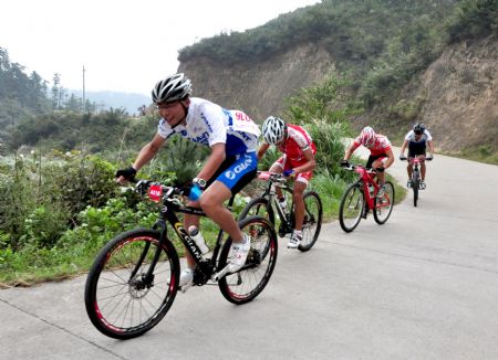 Cyclists contend to outspeed one another on the gyroidal highway up the mountains during the 2nd Pan- Yangtze and Zhujiang and Minjiang River International Bicycle Challenge Race, in the Meiling Scenery Resort of Nanchang, east China's Jiangxi Province, Sept. 28, 2009.(Xinhua/Xiong Jiafu)