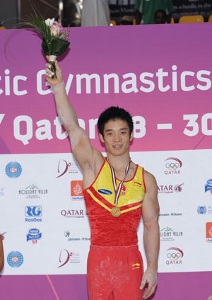 Gold medalist Dong Zhendong of China stands on the podium after winning the men's parallel bars final at the Doha Gymnastics World Cup at the Aspire Academy in Doha, capital of Qatar, Sept. 30, 2009. (Xinhua/Chen Shaojin)