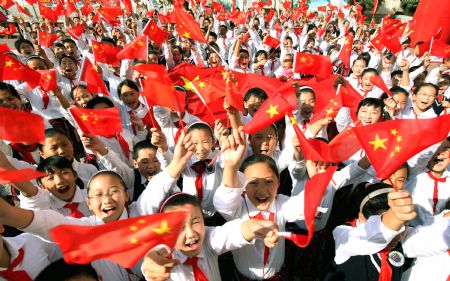 Pupils wave Chinese national flags during a celebration for the 60th anniversary of the founding of the People's Republic of China, in Lianyungang, east China's Jiangsu Province, Sept. 30, 2009.
