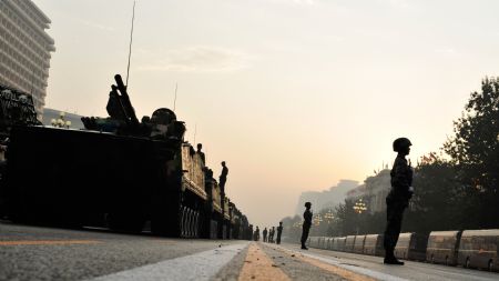 Soldiers guard vehicles which will take part in the celebrations for the 60th anniversary of the founding of the People's Republic of China, in Beijing, capital of China, Oct. 1, 2009. 