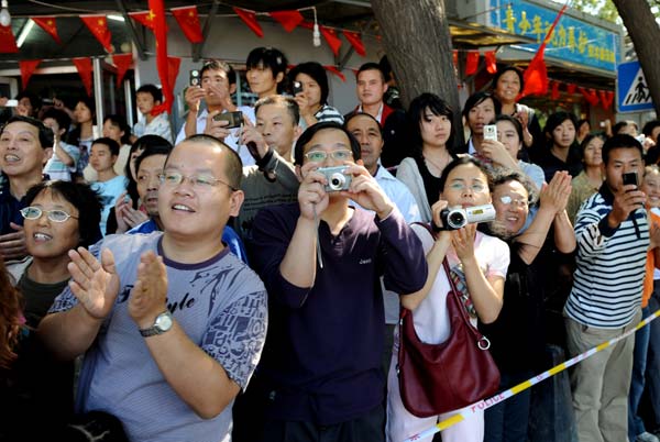 Local residents gather to welcome people taking part in a parade of the celebrations for the 60th anniversary of the founding of the People's Republic of China, in Beijing, capital of China, Oct. 1, 2009. 
