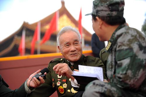 Wu Cheng, a hero solider who has fought the Anti-Japanese War and Korean War, tells his stories to the journalist [Xinhua]