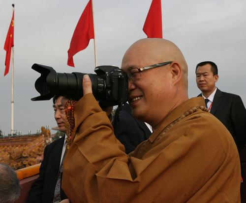 Senior Monk from Beijing Buddhism Association takes photos while waiting for the gala to begin. [Xinhua]