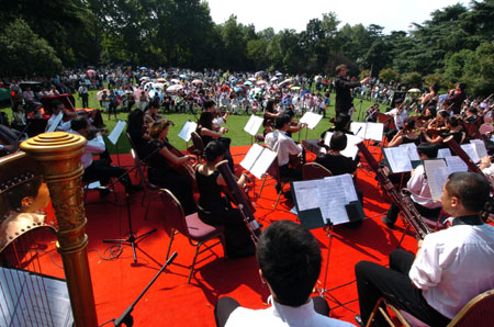 The symphony orchestra play accompanying melody during a symphonic poem recitation show of Ode to Homeland, an outdoor public performance at the side of the West Lake with the musical obbligato by a symphony orchestra, in close range with the audience, in Hangzhou, capital of east China's Zhejiang Province, Oct. 2, 2009. (Xinhua/Shi Jianxue) 