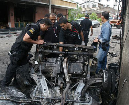 Thai police officers inspect the site of a car bomb attack in Sungai Kolok, a border town in Narathiwat province.(Xinhua/AFP Photo) 