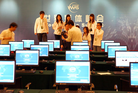 Volunteers for the World Media Summit test computers in the press center at the Beijing News Plaza Hotel in Beijing, capital of China, on Oct. 8, 2009. Nearly 100 reporters have signed in at the press center up to Thursday morning to cover the summit, to be held on Oct. 8-10. (Xinhua/Xu Xianhui) 