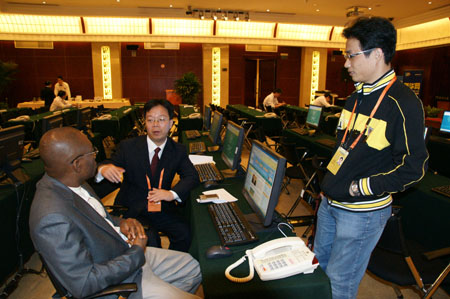 Assistant Editor-in-Chief of News Agency of Nigeria Tony Nwosu (L1) talks with Liu Jiawen (C), director of the World Media Summit press center at the Beijing News Plaza Hotel in Beijing, capital of China, on Oct. 8, 2009. Nearly 100 reporters have signed in at the press center up to Thursday morning to cover the summit, to be held on Oct. 8-10.(Xinhua/Xu Quanyu)