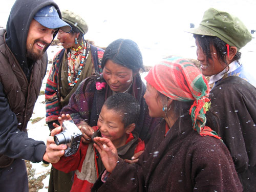 Tom Carter (L) shares his photos with local people in China. [File photo]
