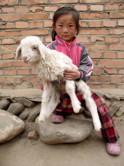 Mongolian girl with her pet lamb (Photo by Tom Carter)