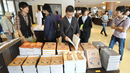 Visitors read books about Emperor Yongzheng during the exhibition about Emperor Yongzheng (1678-1735) of the Qing Dynasty in Taipei, southeast China's Taiwan Province, Oct. 9, 2009.[Wu Ching-Teng/Xinhua]