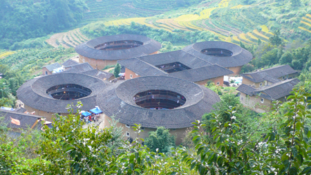 Photo taken on Oct. 6, 2009 shows the Tianluokeng Tulou, earth buildings in Chinese, in Nanjing County, southeast China's Fujian Province. Built on a base of stone, the thick walls of Tulou were packed with dirt and fortified with wood or bamboo internally. The architectural arts of the Fujian Tulou can be traced back nearly 1,000 years, and their design incorporates the tradition of fengshui (favorable siting within the environment). Yang Xiaoming/Xinhua]