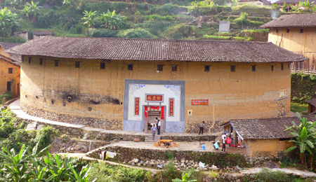 Photo taken on Oct. 6, 2009 shows the Yuqing Lou, one of the Chuxi Tulou, earth buildings in Chinese, in Yongding County, southeast China's Fujian Province. Built on a base of stone, the thick walls of Tulou were packed with dirt and fortified with wood or bamboo internally. The architectural arts of the Fujian Tulou can be traced back nearly 1,000 years, and their design incorporates the tradition of fengshui (favorable siting within the environment). [Yang Xiaoming/Xinhua]