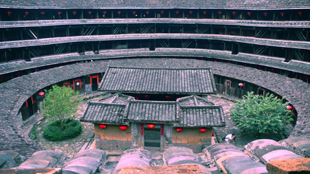 Photo taken on Oct. 6, 2009 shows the Chuxi Tulou, earth buildings in Chinese, in Yongding County, southeast China's Fujian Province. Built on a base of stone, the thick walls of Tulou were packed with dirt and fortified with wood or bamboo internally. The architectural arts of the Fujian Tulou can be traced back nearly 1,000 years, and their design incorporates the tradition of fengshui (favorable siting within the environment). [Yang Xiaoming/Xinhua]