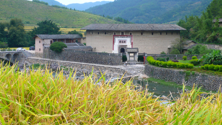 Photo taken on Oct. 5, 2009 shows the Zhenfulou, one of the Tulou, earth buildings in Chinese, in Yongding County, southeast China's Fujian Province. Built on a base of stone, the thick walls of Tulou were packed with dirt and fortified with wood or bamboo internally. The architectural arts of the Fujian Tulou can be traced back nearly 1,000 years, and their design incorporates the tradition of fengshui (favorable siting within the environment). [Yang Xiaoming/Xinhua]