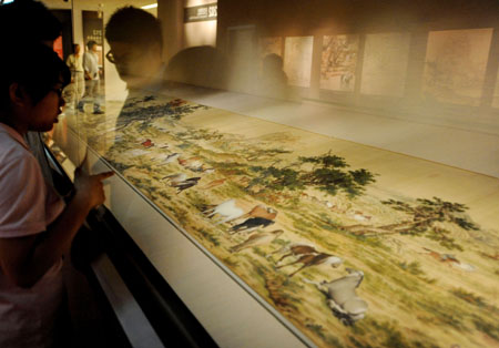 Visitors view a painting by artist Lang Shining during the exhibition about Emperor Yongzheng (1678-1735) of the Qing Dynasty in Taipei, southeast China's Taiwan Province, Oct. 9, 2009.(Xinhua/Wu Ching-Teng)