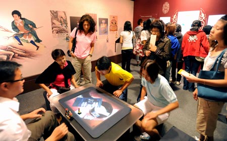 Visitors learn about the history of Qing Dynasty through multimedia during the exhibition about Emperor Yongzheng (1678-1735) of the Qing Dynasty in Taipei, southeast China's Taiwan Province, Oct. 9, 2009.(Xinhua/Wu Ching-Teng)