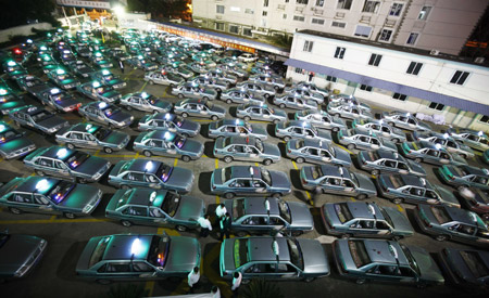 Taxis of which the taxi fee system will be adjusted, park at a taxi company in Shanghai, east China, Oct. 11, 2009. (Xinhua/Pei Xin)