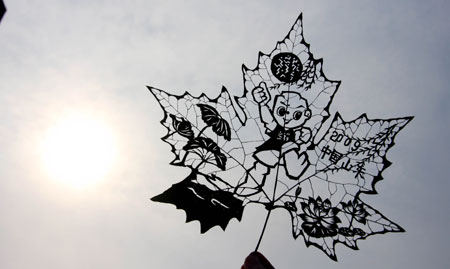 Photo taken on Oct. 11, 2009 shows the leaf carving works made by Du Wanli during an activity at the Quancheng Plaza in Jinan, capital of east China's Shandong Province. Du Wanli made a series of leaf carving works to express her good wishes to the 11th National Games of China which will open in Jinan on Oct. 16, 2009. [Zhao Xiaoming/Xinhua]