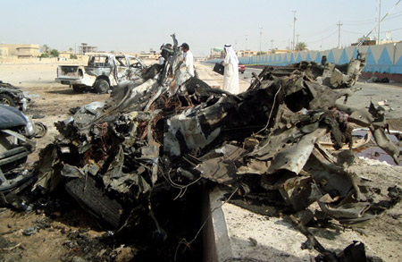 A policeman inspects the site of twin car bombs in Ramadi, the capital of Anbar province in western Iraq, October 11. [Xinhua/AFP]