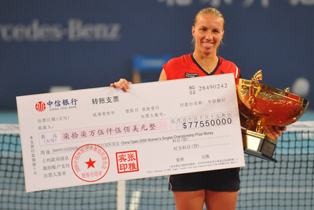 Svetlana Kuznetsova of Russia holds up the trophy and bonus cheque during the awarding ceremony after winning women's singles final match against Agnieszka Radwanska of Poland at the 2009 China Tennis Open Tournament in Beijing, Oct. 11, 2009. Kuznetsova won 2-0, and claimed the title. [Luo Xiaoguang/Xinhua]