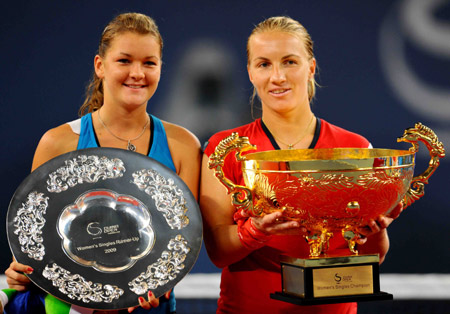 Svetlana Kuznetsova of Russia (R) and Agnieszka Radwanska of Poland hold up their trophies during the awarding ceremony after women's singles final at the 2009 China Tennis Open Tournament in Beijing, Oct. 11, 2009. Kuznetsova beat Radwanska 2-0, and claimed the title. [Chen Jianli/Xinhua]